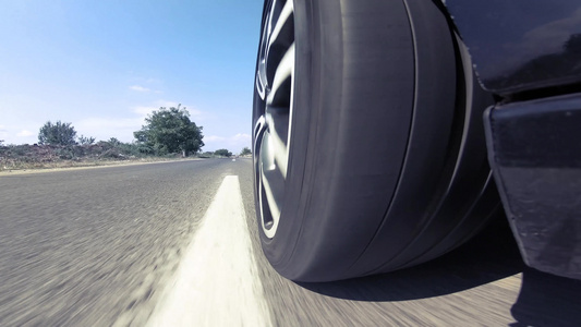 车轮在高速公路上驾驶时快速旋转的近视路景视频