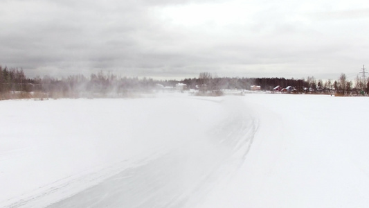 冬季雪覆盖湖的冰雪轨道驾驶车空中观光视频