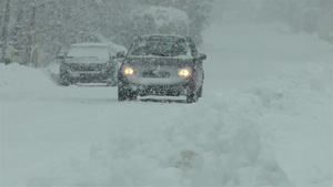 在雪覆盖的路上驾驶的车15秒视频