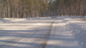 在阳光明媚的白天穿过冬季森林驾车在雪地高速公路上行驶21秒视频