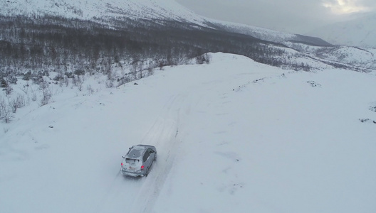 雪山路上驾驶汽车的空中航向视频