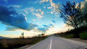 开着汽车在通往日出充满活力的天空的农村公路上行驶30秒视频