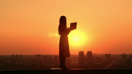日出时有妇女用笔记本电脑户外城市风景视频