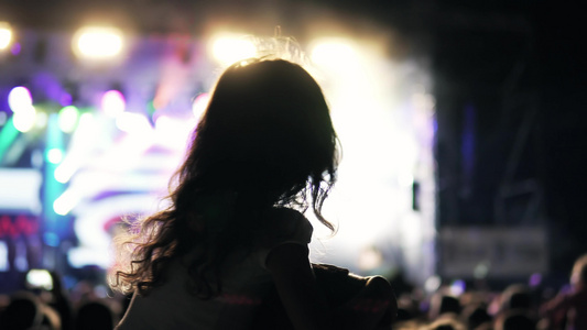 在户外音乐节公共音乐会上一头卷发坐在肩上的剪影女孩视频