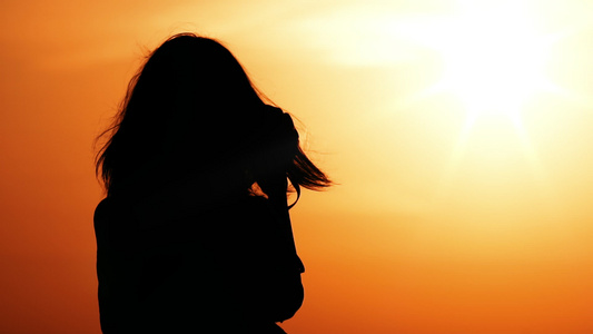 女摄影师在日出温暖的天空和橙色太阳视频