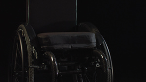 黑暗背景的黑黑色轮椅16秒视频