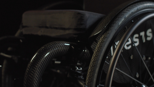 黑暗背景的黑黑色轮椅视频
