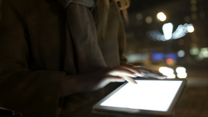 妇女走在晚上街上使用平板电脑29秒视频