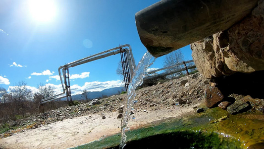 泉水自来水的矿泉水在春天的阳光下流缓慢地回流视频