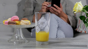 女人用智能手机在沙发里喝橙子汁28秒视频