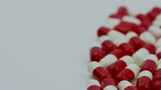 红色和白色的抗生素胶囊丸从右向左滑动和移动耐药性概念视频