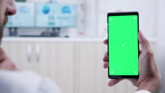 持有带有绿色屏幕模型的手机视频