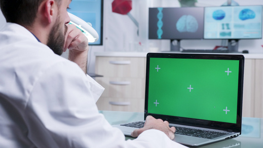 使用绿色屏幕笔记本电脑的医务人员肩上拍摄的静态镜头视频