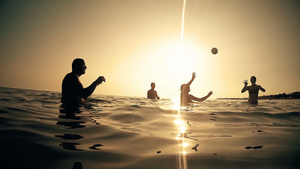 日落时在海水中玩沙滩排球的年轻人19秒视频