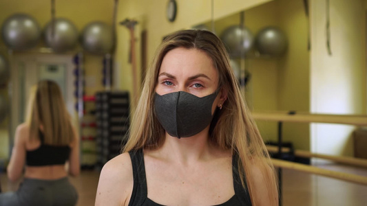美丽的女性健身教练教练脱下两个医疗防护面罩可以正常视频