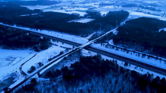 寒冷的沥青国度开阔的道路穿过冬季雪田和日落或日出时视频