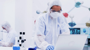 女科学家在穿着全套设备的现代化学实验室里站起来在电脑45秒视频