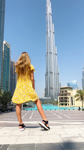 快乐的女孩在杜拜散步在背景中有摩天大楼视频