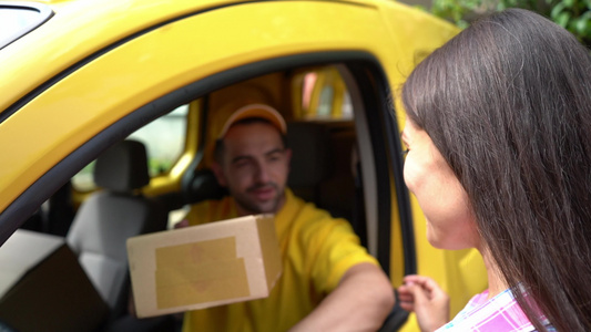黄色货车的送信员给女性顾客包裹视频