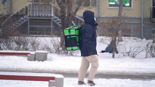 送信员在冬天带着背包送食物视频