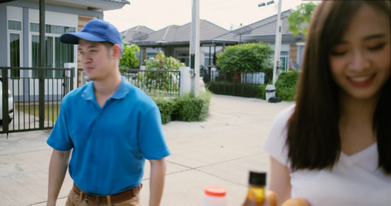 穿蓝制服的亚洲人送食物给接收者客户前门店吃水果和蔬菜视频