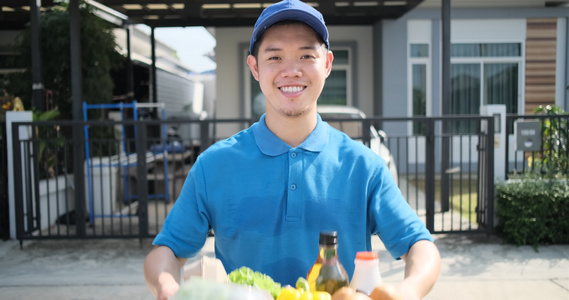 穿蓝制服的亚洲人送食物给接收者客户前门店吃水果和蔬菜视频