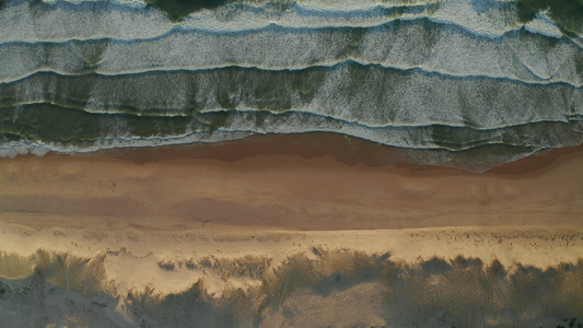 美丽的海滩风景广阔沙丘和海浪在白泡沫中坠落空中从上向下视频