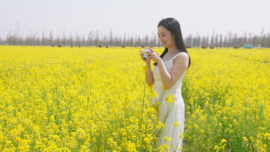 长裙女人在油菜花田里拍照视频