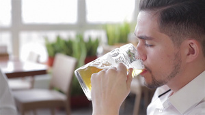 英俊年轻男子喝啤酒的肖像15秒视频