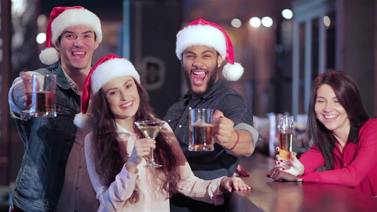 三个朋友在圣塔帽和酒吧后面的女孩喝杯啤酒视频