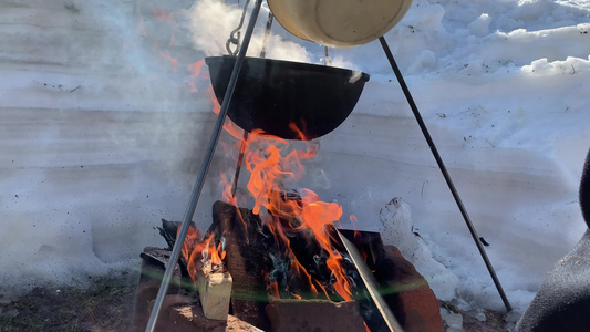 一个旅游锅在冬天的营火上挂着在冬天用大自然的火做饭视频