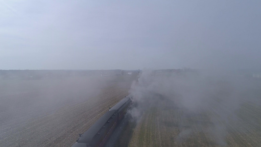 通过修复后的蒸汽机车和客车的烟雾鸟瞰图客车在火车后面视频