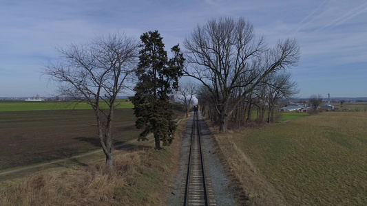 修复后的蒸汽机车和客车的鸟瞰图在火车前穿过乡村吹着视频