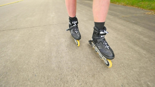 在松树林中随机滑轮滑勒芒腿在炎热的夏日在沥青上溜冰视频