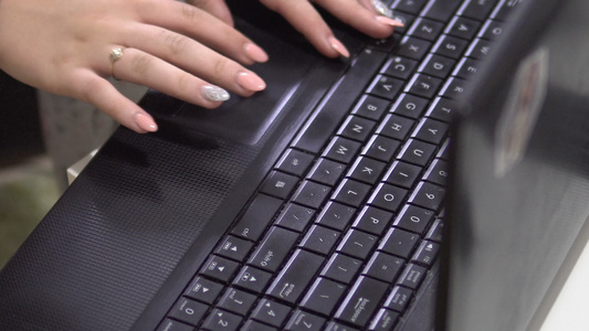 在笔记本电脑键盘上打字时用修指甲钉的女性手视频