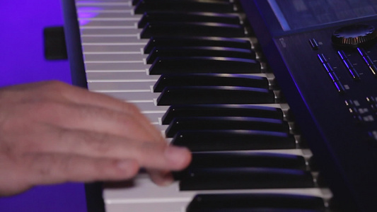 音乐家在键盘合成器钢琴键上演奏的慢动作视频