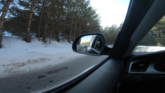 在冬季雪雪中驾驶车在雪覆盖的雪山路上行驶通过侧面镜子视频