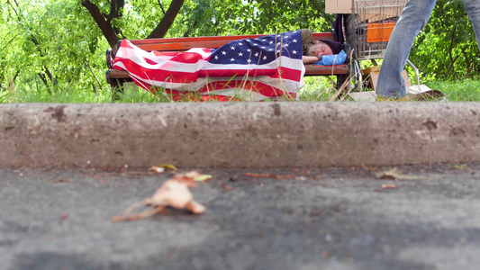 看到一个无家可归的人睡在街上长椅上视频