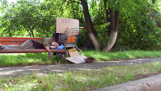 看着老乞丐睡在城市公园的长椅上视频