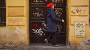 红帽子女人敲门铃旧欧洲街的大门涂上涂鸦28秒视频