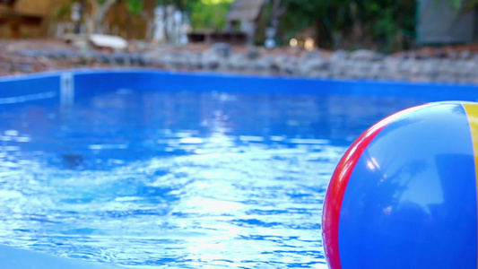 彩色的沙滩球在游泳池中打到另一个球视频