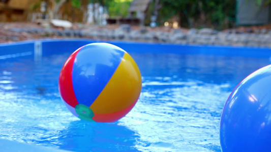彩色的海滩球投进游泳池的水中视频
