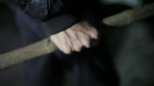 人手紧紧地握着木棍在夜晚和恐惧的氛围中被射杀或者与视频