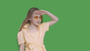少女少年在透明的绿色背景上望着远方戴着黄色眼镜和连衣裙19秒视频