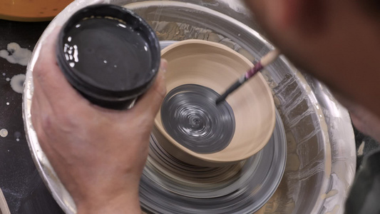 陶罐上的陶画手工制作车间陶瓷陶器用画笔在陶艺班陶工视频