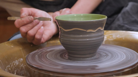 陶罐上的陶画手工制作车间陶瓷陶器用画笔在陶艺班陶工视频