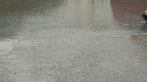女孩和男孩的双腿在雨路边的灰色湿润中行走7秒视频