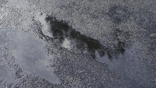 用雨滴在沥青上的水坑视频