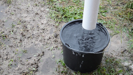 雨水滴从屋顶排水沟到桶里视频