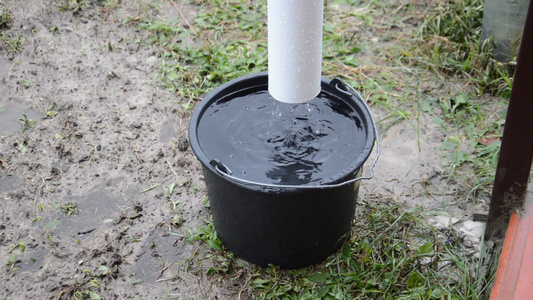 雨水滴从屋顶排水沟到桶里视频